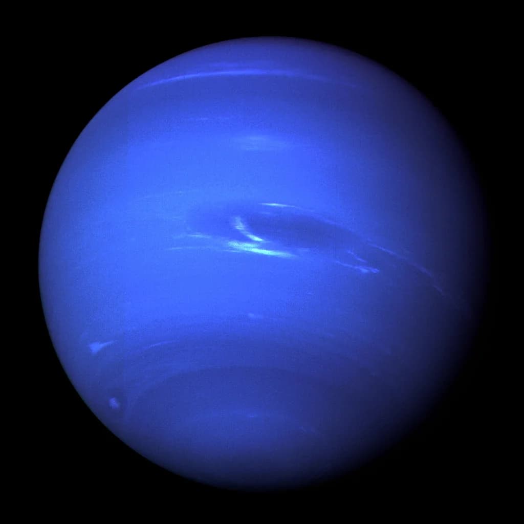 Neptune as a deep blue disc with cirrus clouds and the Great Dark Spot visible.