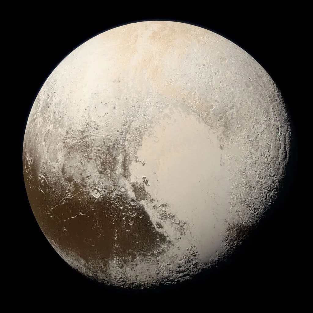 Pluto in true colour — pale ice plains, the heart-shaped Tombaugh Regio, and reddish tholin terrain.