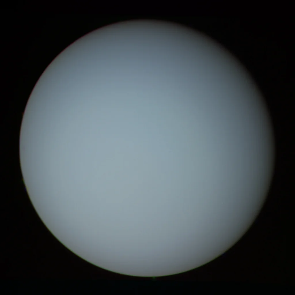 Uranus as a pale blue-green disc, near-featureless and tilted nearly vertically.