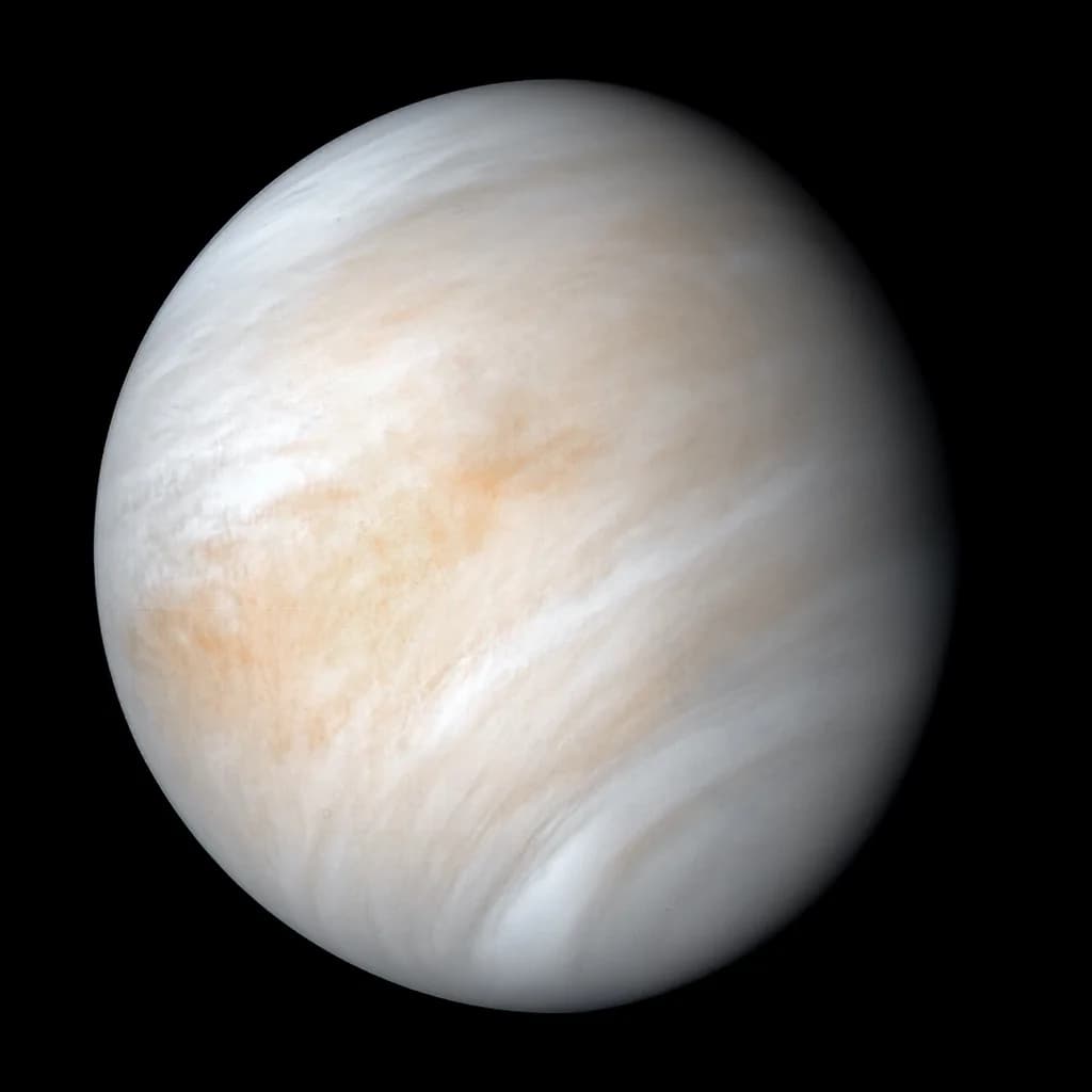 Venus as a full disc — pale cream-and-tan cloud bands wrapping the planet.